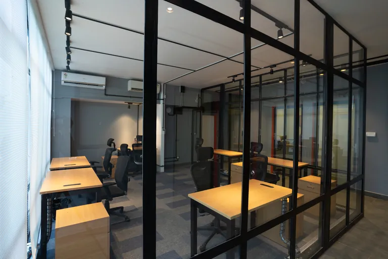 Glass-partitioned work areas at Suits Mansarovar